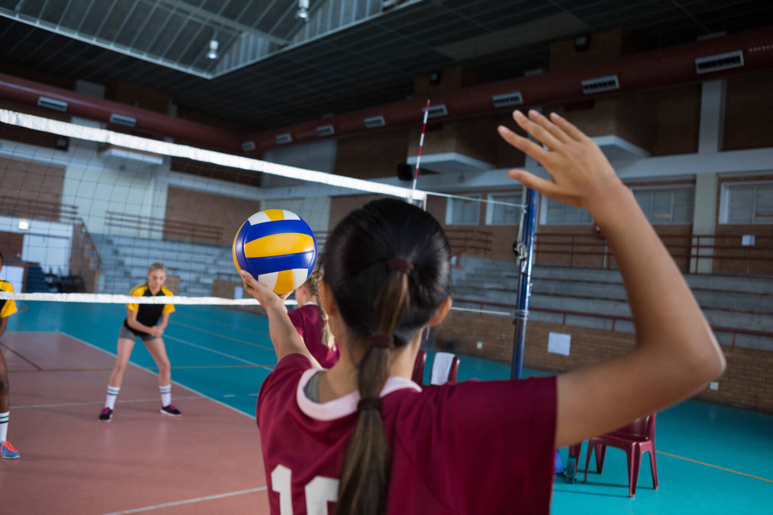 Female volleyball players playing volleyball in the court